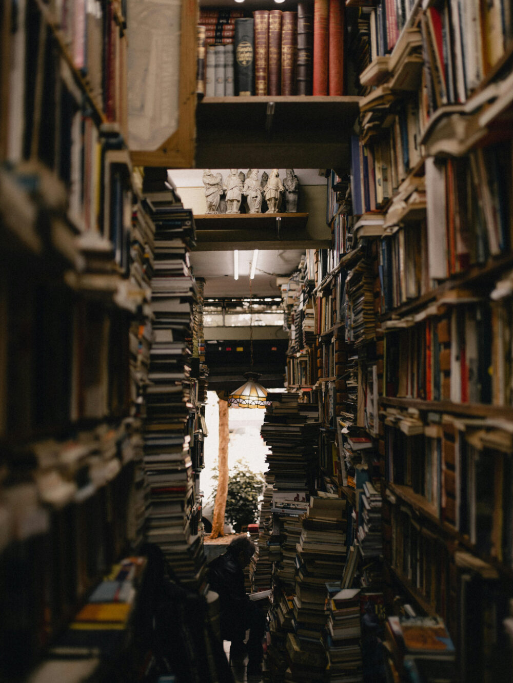 Foto de pilhas de livros em um corredor.